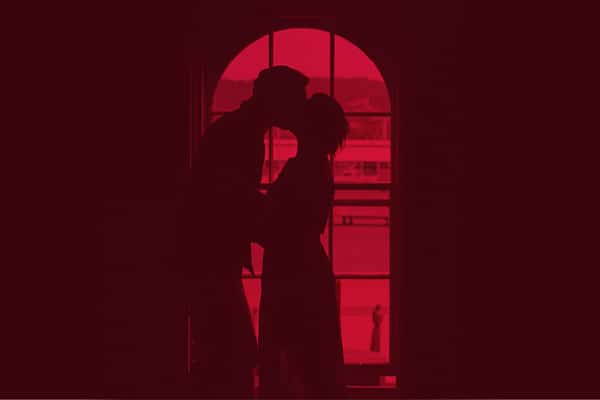 A silhouette of a man and a woman kissing